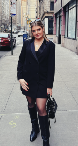 A woman in a black blazer, smiling. 